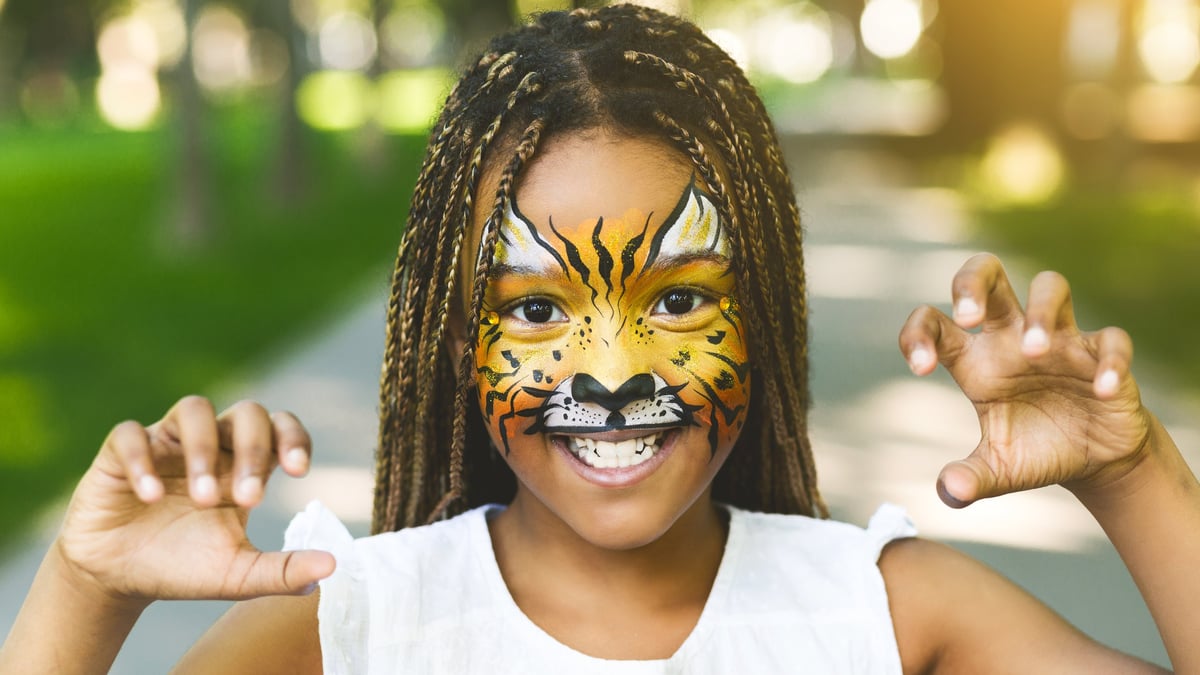 Face painting for kids parties with playful tiger face paint design