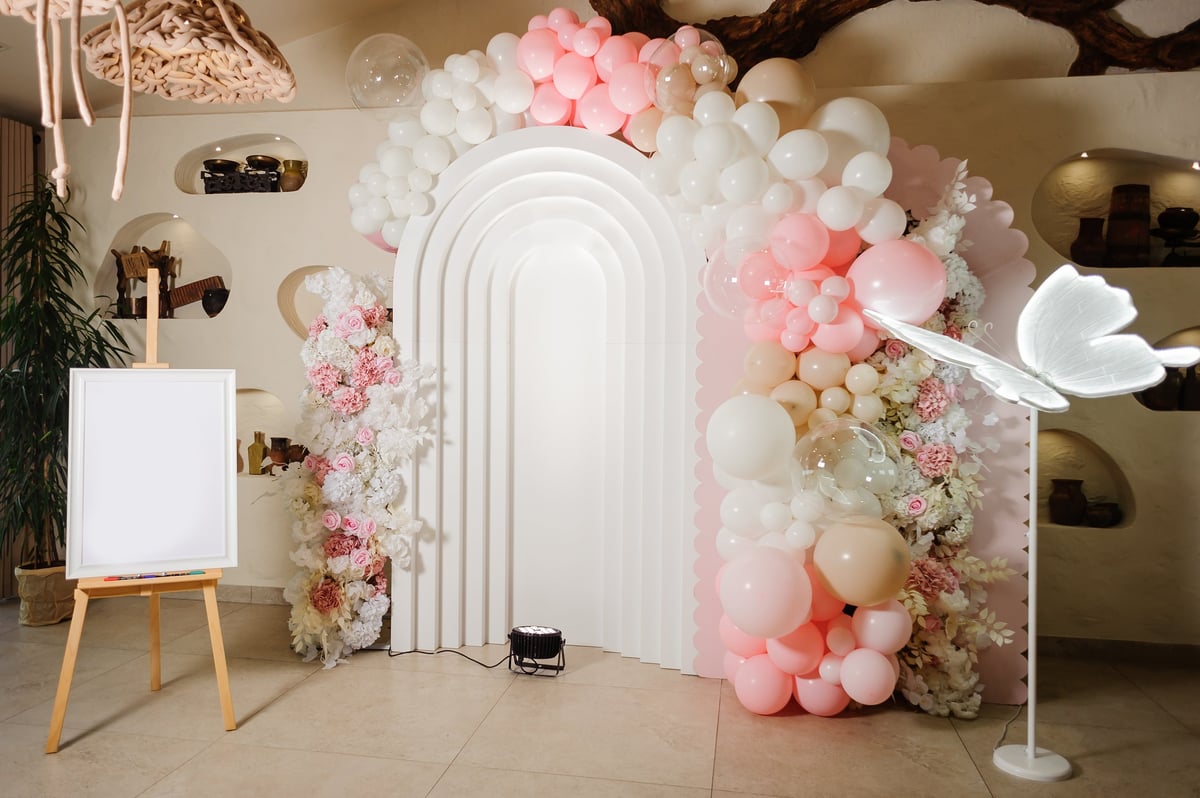 White arch photo zone rental with pink and white balloon garland for showers