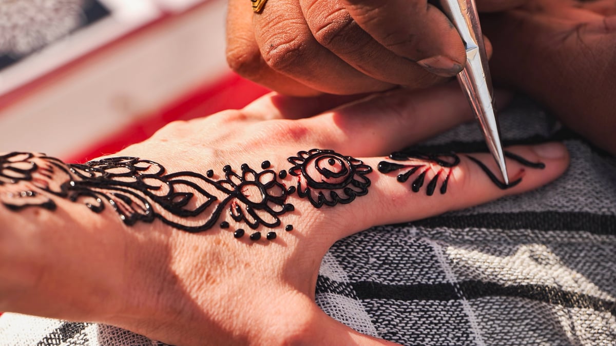 Henna station entertainment with intricate mehndi designs applied at an event