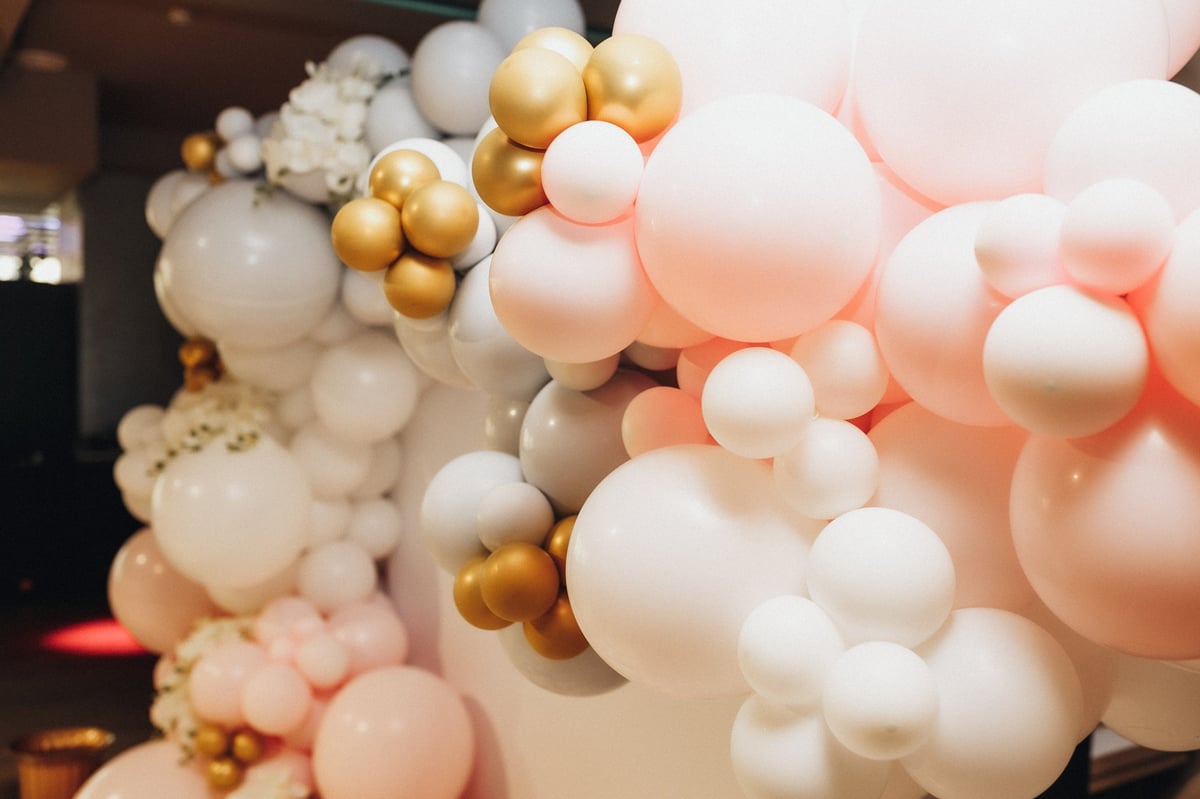 Organic balloon garland arch in pink, white and gold installed for a party